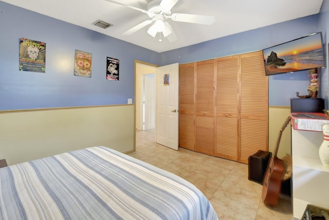 bedroom featuring ceiling fan, a closet, and light tile patterned floors