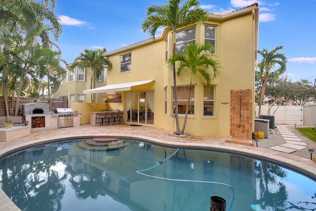 view of pool with a patio, area for grilling, and exterior kitchen