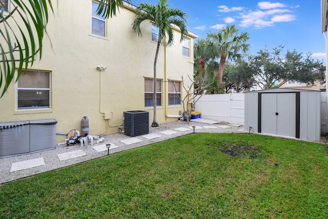 view of yard with central AC unit and a storage shed