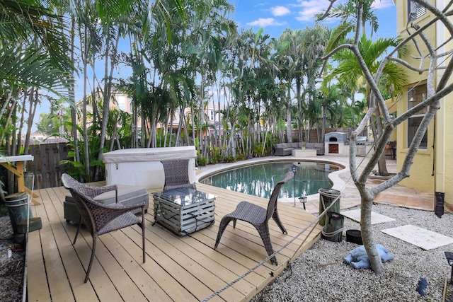 view of pool with an outdoor living space, a wooden deck, and a hot tub