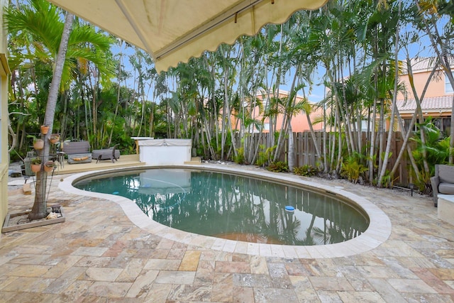 pool at dusk with a patio area