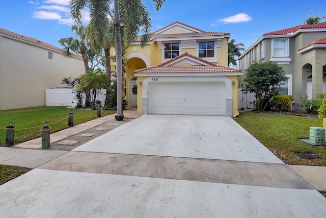 mediterranean / spanish home featuring a front yard and a garage