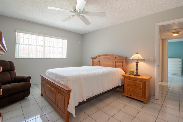 bedroom with a textured ceiling, ceiling fan, and light tile patterned floors