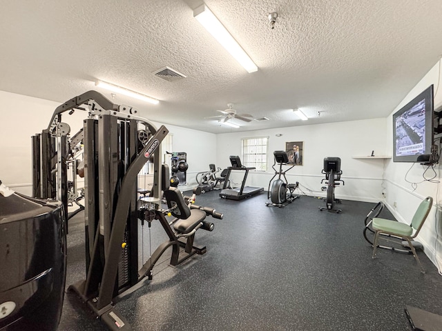 gym with a textured ceiling and ceiling fan