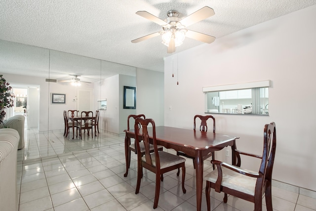 tiled dining area featuring ceiling fan and a textured ceiling