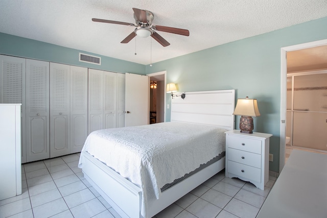 tiled bedroom with ceiling fan, a textured ceiling, and a closet