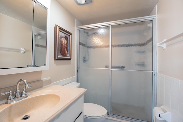 bathroom featuring toilet, tile walls, an enclosed shower, and vanity