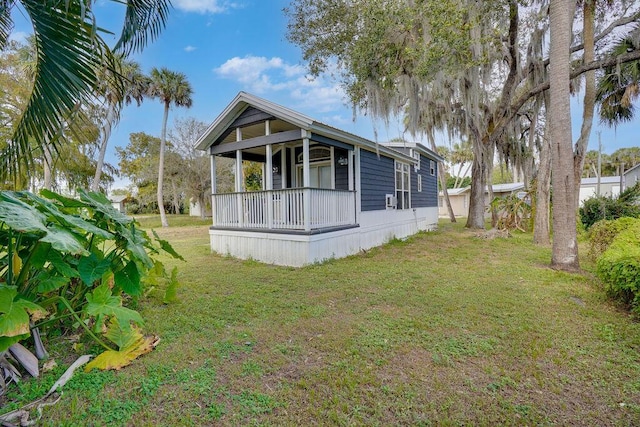 back of property featuring a lawn and a porch