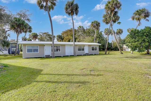 rear view of house featuring a yard