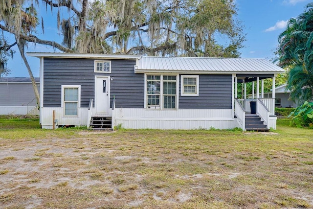 rear view of property featuring a yard