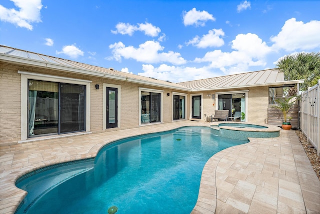 view of swimming pool featuring an in ground hot tub and a patio