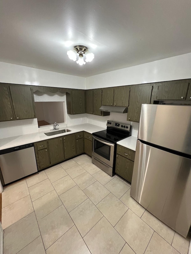 kitchen featuring light tile patterned floors, a sink, stainless steel appliances, light countertops, and under cabinet range hood