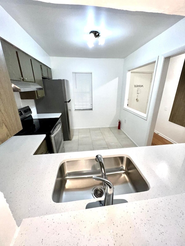 kitchen featuring a sink, light countertops, under cabinet range hood, and stainless steel appliances