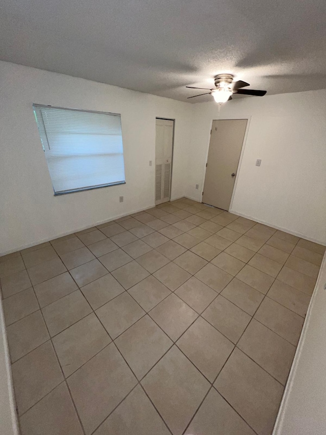 spare room with ceiling fan and a textured ceiling