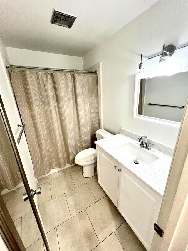 unfurnished bedroom featuring dark wood-style flooring, multiple closets, visible vents, a ceiling fan, and a textured ceiling