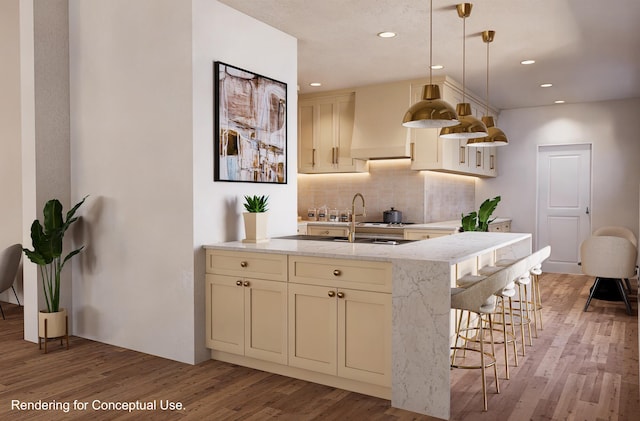 kitchen featuring decorative light fixtures, tasteful backsplash, light stone counters, hardwood / wood-style floors, and a breakfast bar area