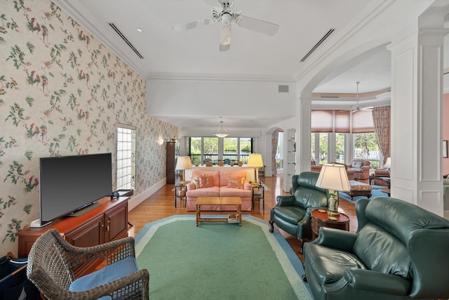 living room with ceiling fan, ornamental molding, and light hardwood / wood-style floors