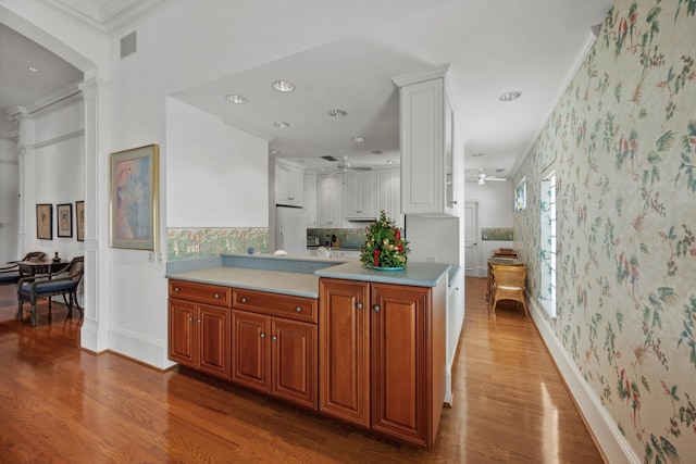 kitchen featuring ceiling fan, white cabinets, hardwood / wood-style flooring, ornamental molding, and white fridge