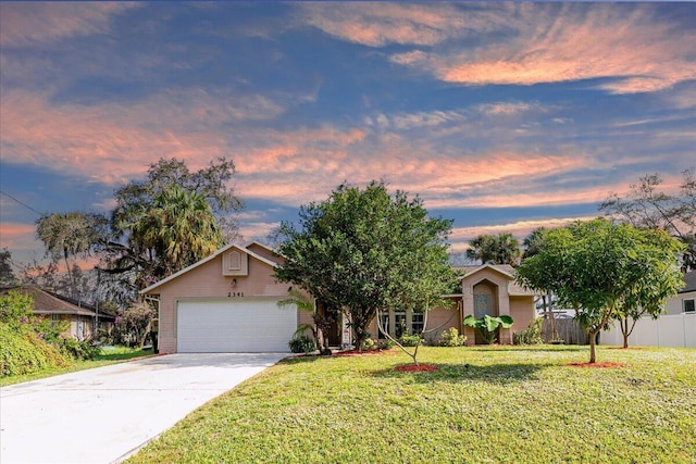 ranch-style home featuring a lawn and a garage