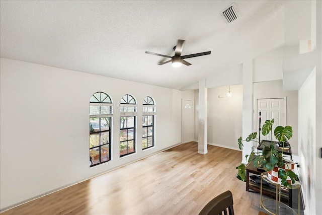 sitting room with ceiling fan, lofted ceiling, a textured ceiling, and light hardwood / wood-style flooring