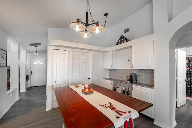 kitchen featuring white cabinets, pendant lighting, and tasteful backsplash