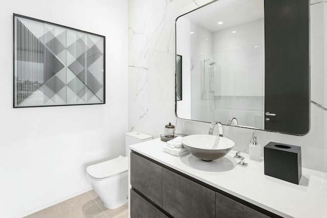 bathroom featuring a shower, vanity, tile patterned floors, and toilet