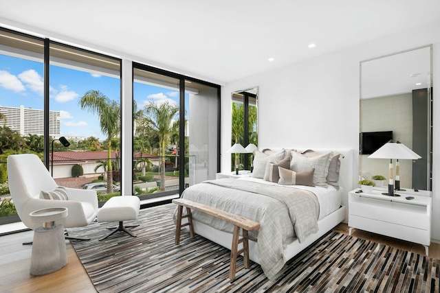 bedroom featuring hardwood / wood-style floors and expansive windows