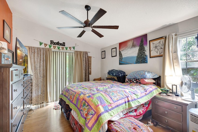 bedroom with light wood-type flooring, ceiling fan, and lofted ceiling