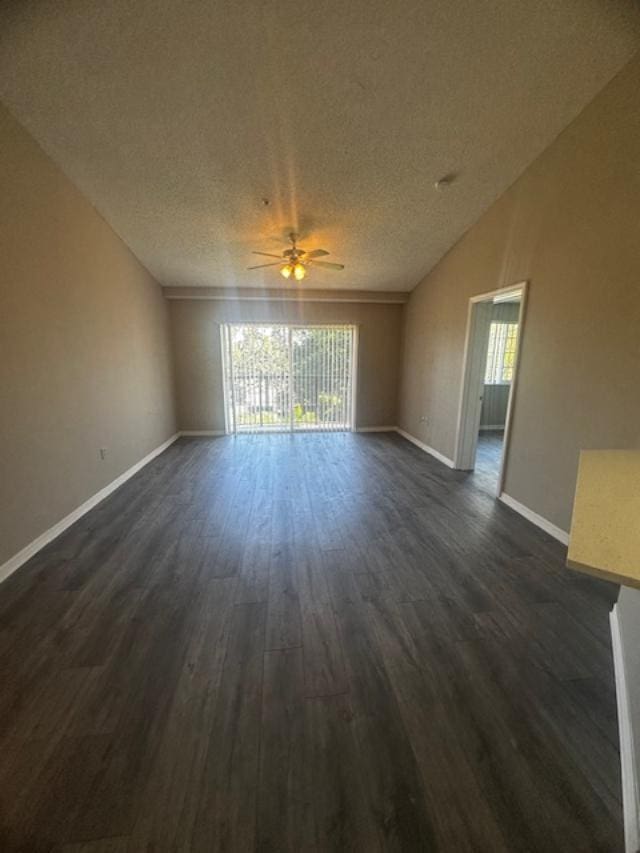 unfurnished room featuring dark hardwood / wood-style floors, ceiling fan, and a textured ceiling