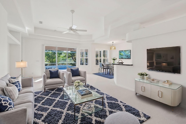 carpeted living room with ceiling fan