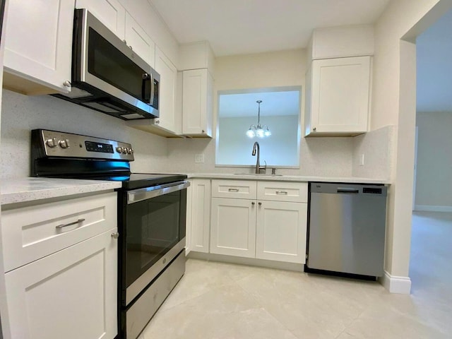 kitchen with white cabinets, decorative light fixtures, sink, and appliances with stainless steel finishes