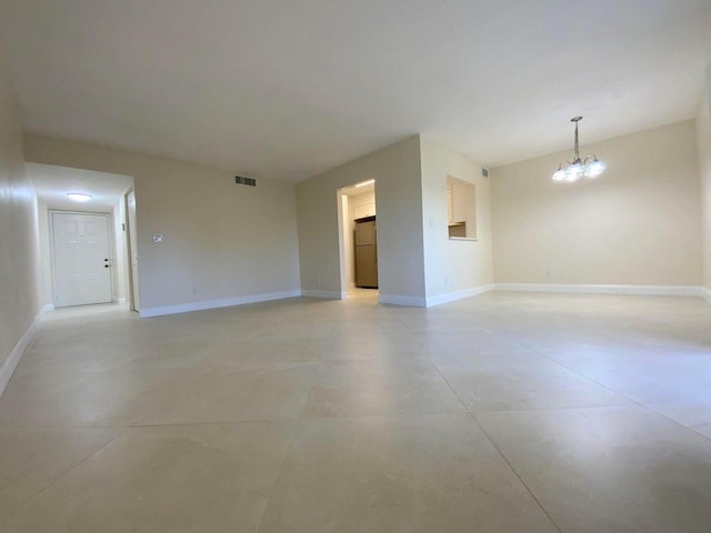 spare room featuring an inviting chandelier