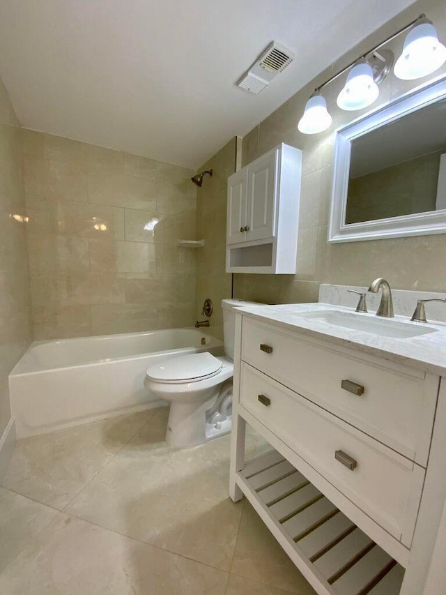 full bathroom with tile patterned flooring, vanity, toilet, and tiled shower / bath