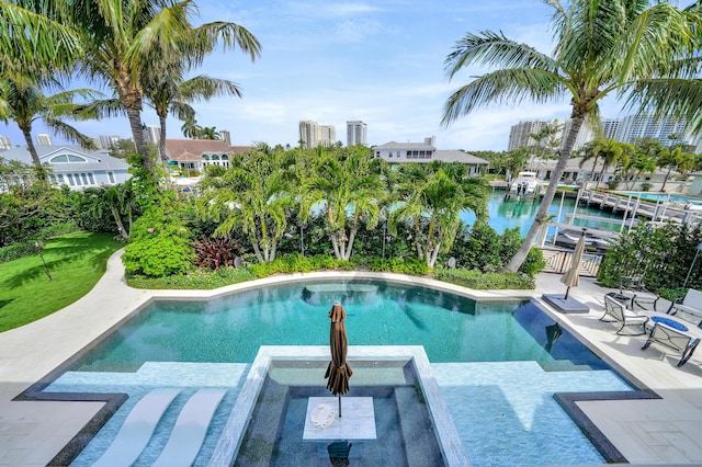 view of swimming pool with an in ground hot tub and a water view