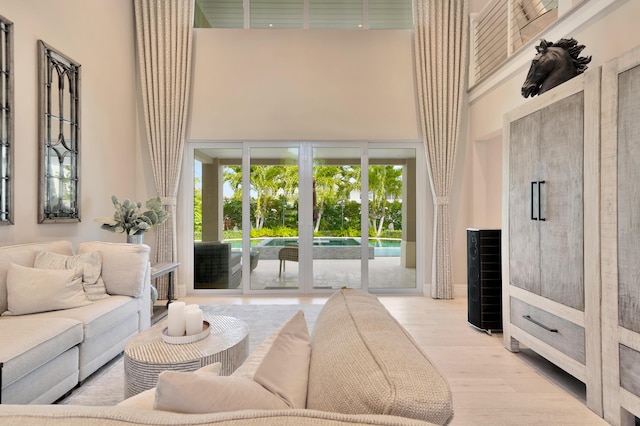 living room with light hardwood / wood-style floors and a high ceiling