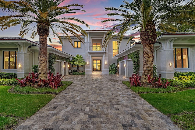 mediterranean / spanish-style house with a lawn and a balcony