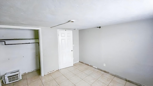 unfurnished bedroom featuring a wall mounted air conditioner and a closet