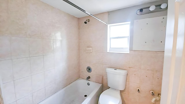 bathroom with tiled shower / bath combo and toilet