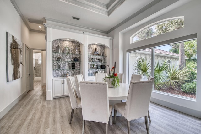 dining room with light wood-style flooring, visible vents, ornamental molding, and baseboards