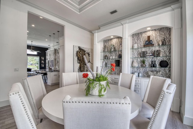 dining space featuring crown molding and hardwood / wood-style flooring