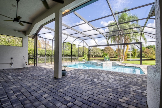 view of swimming pool featuring ceiling fan, an in ground hot tub, glass enclosure, and a patio area