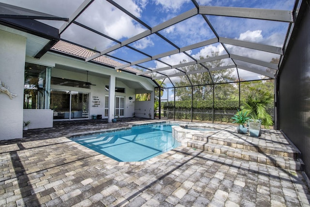 view of pool featuring a patio, an in ground hot tub, ceiling fan, and glass enclosure