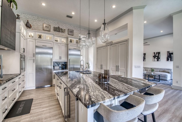 kitchen featuring sink, stainless steel appliances, a kitchen breakfast bar, and a large island with sink