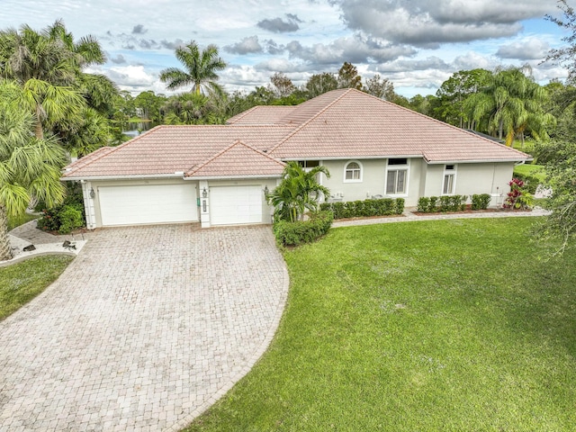 view of front of home with a garage and a front lawn