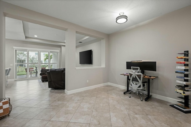 office space featuring light tile patterned floors and a tray ceiling