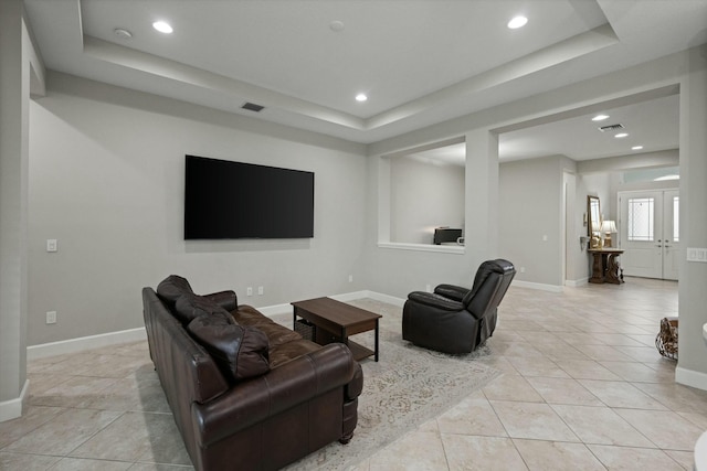 tiled living room featuring a tray ceiling