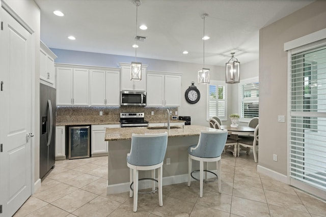 kitchen with white cabinetry, sink, wine cooler, pendant lighting, and appliances with stainless steel finishes