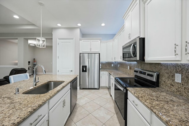 kitchen with sink, decorative backsplash, light tile patterned floors, appliances with stainless steel finishes, and white cabinetry