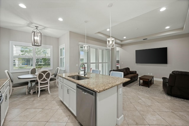 kitchen featuring sink, stainless steel dishwasher, an island with sink, pendant lighting, and white cabinets