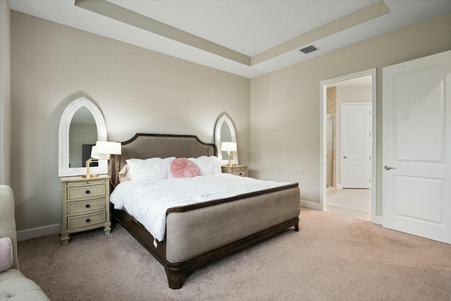 bedroom with a tray ceiling and light carpet